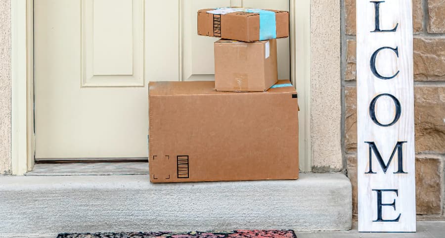 Packages on the doorstep of a home with a welcome sign in State College